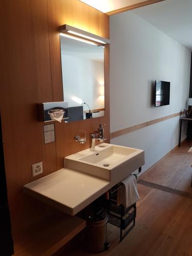 a bathroom with a sink and a mirror at East West Hotel Basel in Basel