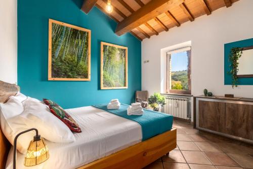 a bedroom with a bed and a blue wall at -Piscina privata- 10 posti letto, Wifi, AC, Garden in Ripatransone