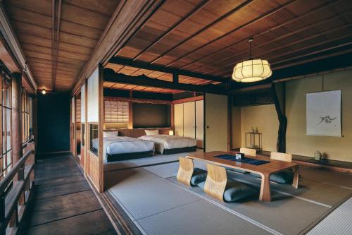a bedroom with a bed and a table in a room at KAZENO Kurayoshi in Kurayoshi