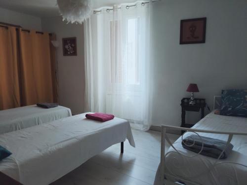 a room with two beds and a window at Maison Berrichonne 2 chambres cour et jardin in Saint-Marcel