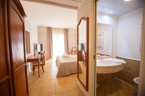 a bathroom with a sink and a table in a room at Dioscuri Bay Palace in San Leone