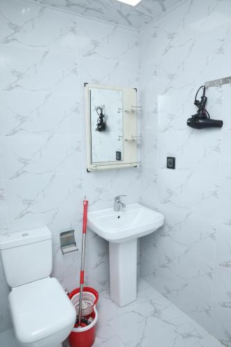 a white bathroom with a toilet and a sink at SunRise in Masazır