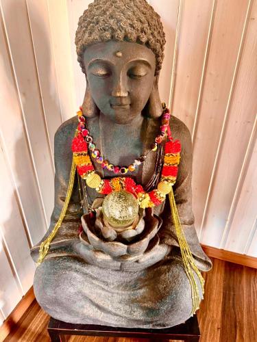 a statue of a buddha sitting on a floor at Zurich near the lake single room in historical house shared Bathroom in Kilchberg