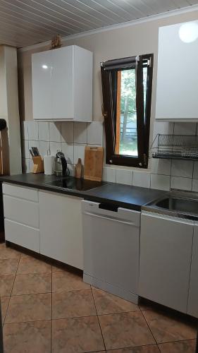 a kitchen with white cabinets and a black counter top at U Hanki in Turawa