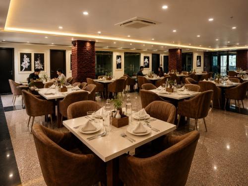 a restaurant with tables and chairs and people sitting at them at Lime Tree Hotel & Banquet Jal Mahal Jaipur in Jaipur