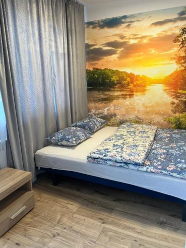 a bed in a room with a view of a river at Apartamenty Harnaś in Rytro