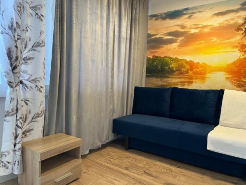 a room with a blue couch in front of a window at Apartamenty Harnaś in Rytro