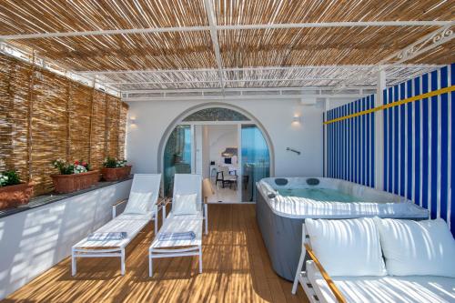 a room with a tub and chairs and a table at Tramonto d'Oro in Praiano