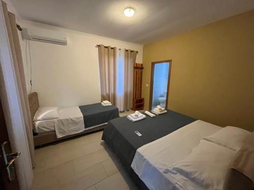 a hotel room with two beds and a mirror at prekal park kamping in Shkodër