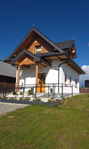 a large white building with a wooden roof at Spis na Podhalu in Koniówka