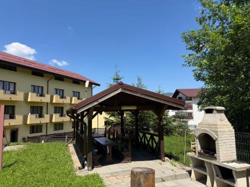 a wooden pavilion with a pizza oven in a yard at Ideal Predeal in Predeal