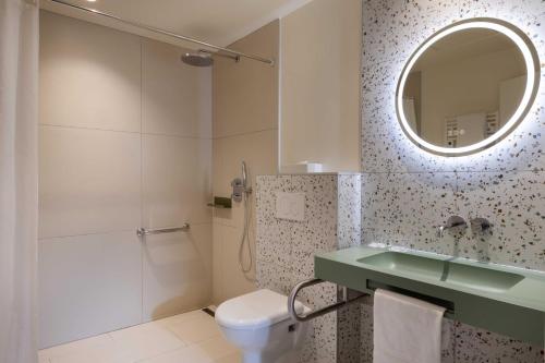 a bathroom with a toilet and a sink and a mirror at Hôtel Kemaris in Biarritz