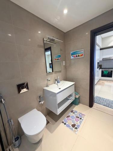 a bathroom with a white toilet and a sink at Segal 2 Hawana Salalah Forest Island in Salalah