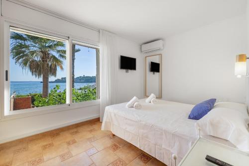 a bedroom with a bed and a view of the ocean at Mora Beach in Tarragona