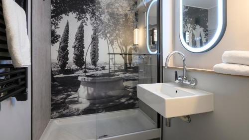 a bathroom with a sink and a mirror at Campanile NATURE - Bollene in Bollène