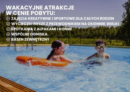 two children in a swimming pool with an advertisement at Moje Miejsce Jura in Kroczyce
