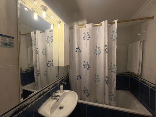 a bathroom with a sink and a tub and a mirror at Hostal Bellas in Ávila