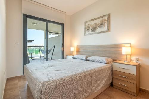 a bedroom with a bed and a table with two lamps at Apartment In Golf Mar Resort in San Jorge