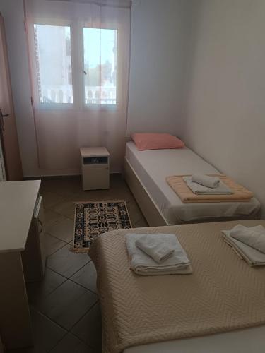 two beds in a small room with a window at Pet Friendly Apartment Ground Floor in Petrovac na Moru