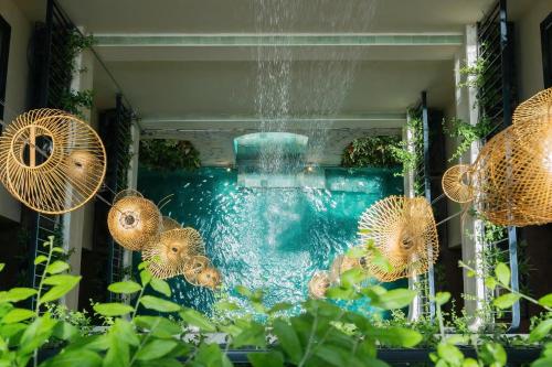 a pool with a water fountain with fish in it at Amsphere Homestay & Restaurant in Hanoi