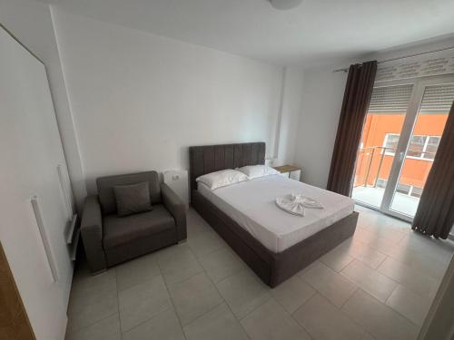 a bedroom with a bed and a chair at Banesa me Qera 15,36 Rana Hedhun in Lezhë