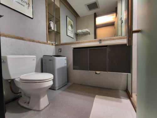 a bathroom with a white toilet and a mirror at High Clouds Hotel Apartment in Guangzhou