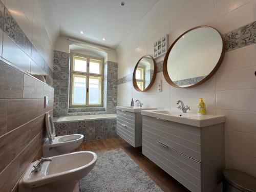 a bathroom with two sinks and a toilet and a mirror at Apartmány u komína in Terezín