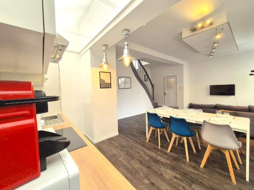 a dining room with a white table and blue chairs at Vilnius - Confort familial in Reims