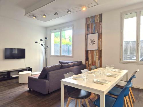 a living room with a table and a couch at Vilnius - Confort familial in Reims