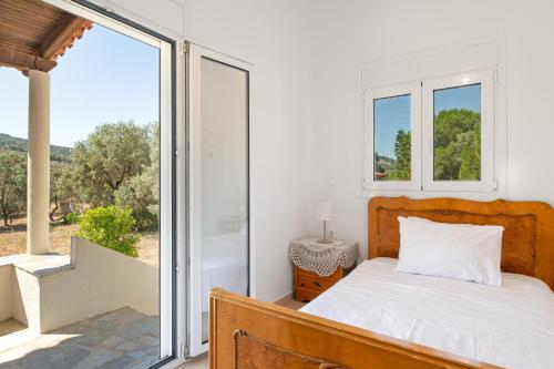 a bedroom with a bed and a large window at Vasso Galati House in Vaia