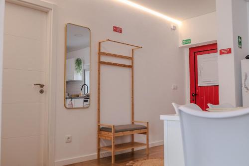 a bathroom with a red door and a mirror at Casa dos Manos in Barbacena