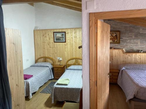 a small room with two beds and a doorway at Casa Casteller in Arfa