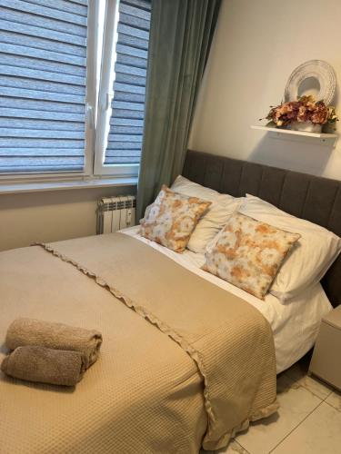 a bedroom with a bed with pillows and a window at Sara Apartament in Turek