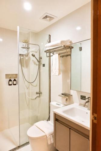 a bathroom with a toilet and a sink and a shower at Starhomes Hotel & Cafe in Tarlac