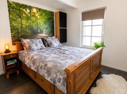 a bedroom with a bed with a painting on the wall at Villa Mar veluwe in Ermelo