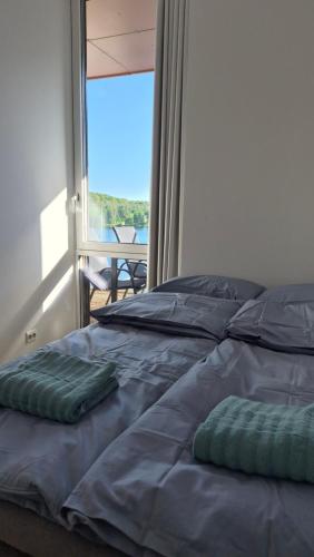 a bed with two pillows on it in front of a window at Seabreeze Suite in Arendal