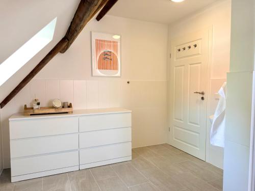 a kitchen with white cabinets and a staircase at HyggeLiving - 120qm - Boxspringbetten - 55" Smart TV - Küche - Parkplatz - bis 8 Pers - BESTLAGE in Wernigerode