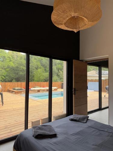a bedroom with a bed and a view of a pool at La Villa Andromède 10pers in Martillac