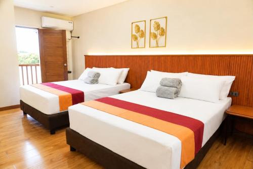 two beds in a hotel room with at Starhomes Hotel & Cafe in Tarlac
