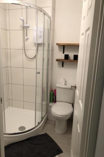 a bathroom with a toilet and a glass shower at Captivating 1-Bed Apartment in Hednesford in Cannock