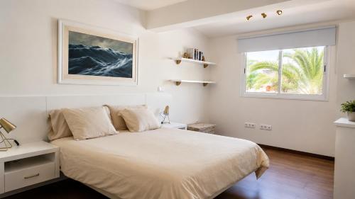 a white bedroom with a bed and a window at Brisa Vacacional - Adults Only in Corralejo
