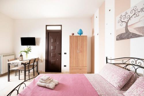 a bedroom with a pink bed with a pink blanket at Lu Marchese in Minervino di Lecce
