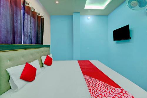 a room with a bed with red pillows and a tv at Hotel O City View in Dānāpur