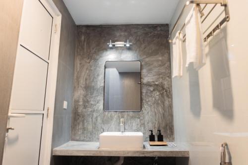 a bathroom with a sink and a mirror on a wall at Amaria Maldives in Finolhus