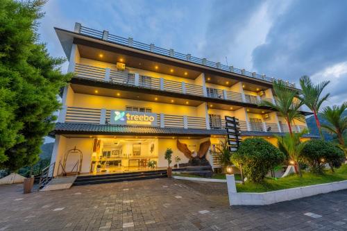 a hotel with a large building with a driveway at Treebo Misty Garden Resort & Spa With Swimming Pool in Munnar