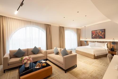 a hotel room with a bed and a living room at Grand Bloom Hotel in Baghdād