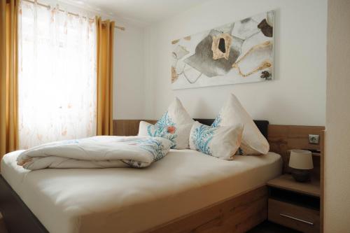 a bedroom with a bed with pillows and a window at Ferienwohnung am Waldweg in Kolsass