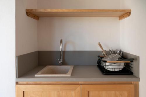 a kitchen counter with a sink and a basket of utensils at Masseria Galeasi in Grottaglie