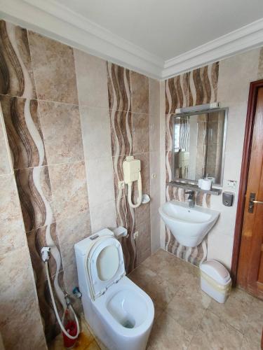 a bathroom with a toilet and a sink at Newland Sarl in Douala