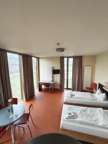 a hotel room with two beds and a table and chairs at DJH Jugendherberge Xanten in Xanten